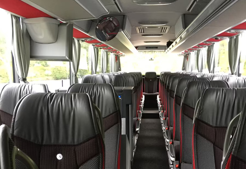 Mercedes-Benz Tourismo coach cabin with dark seats and red trim