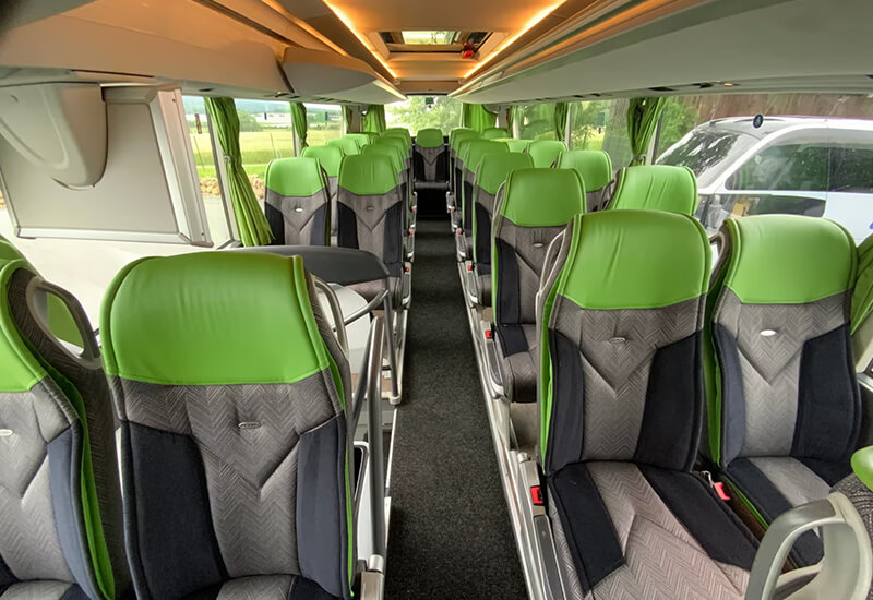 Green-and-gray seats along the aisle of a Setra double-deck coach